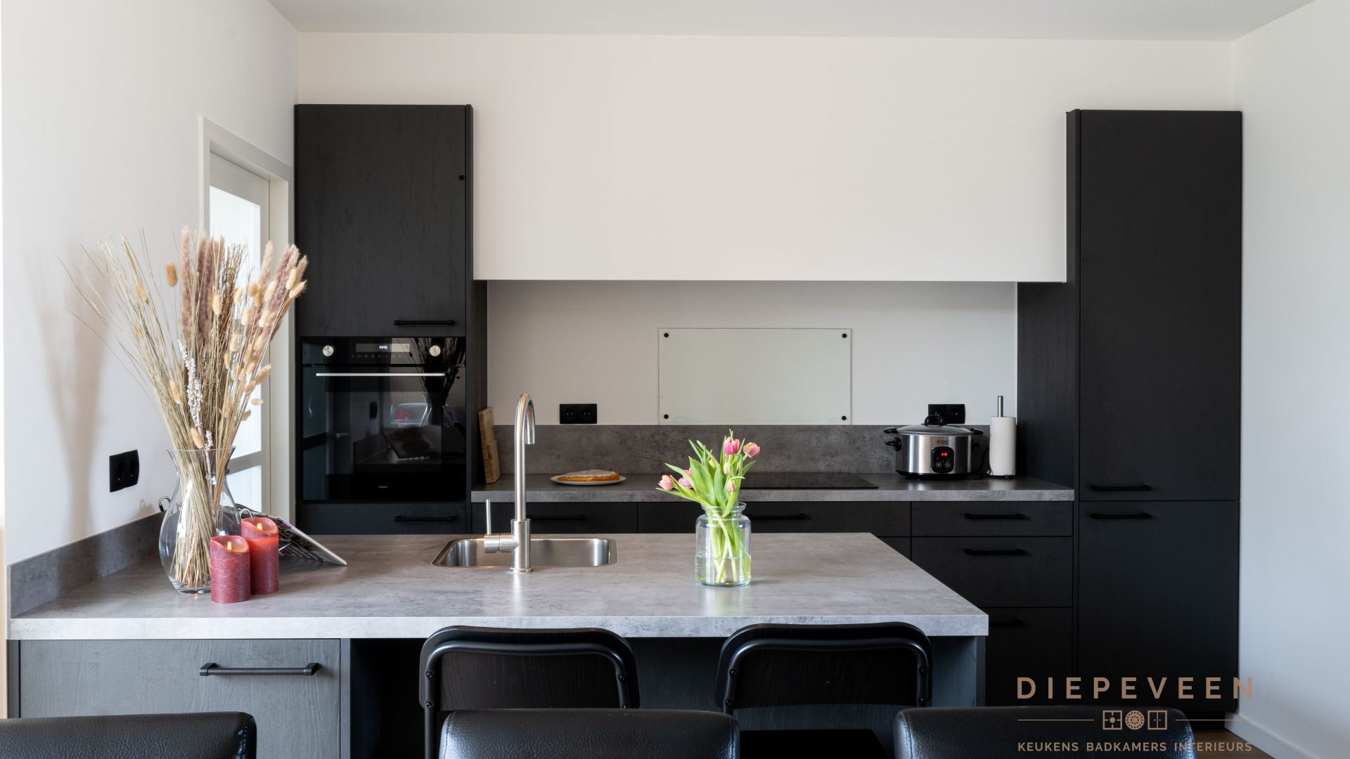 Zwarte keuken met betonlook werkblad